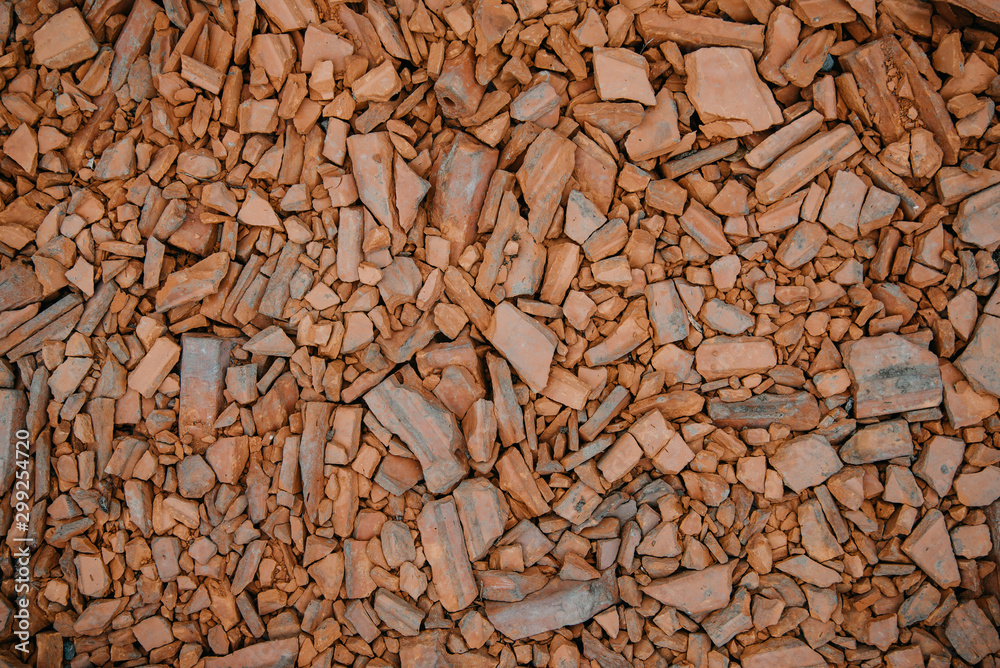Background in grunge style from the shards of old broken orange bricks. Fragments of small pieces. The view from the top. The surface of the table for shooting flat lay. Copy space Background in grunge style from the shards of old broken orange bricks. Fragments of small pieces. The view from the top. The surface of the table for shooting flat lay. Copy space