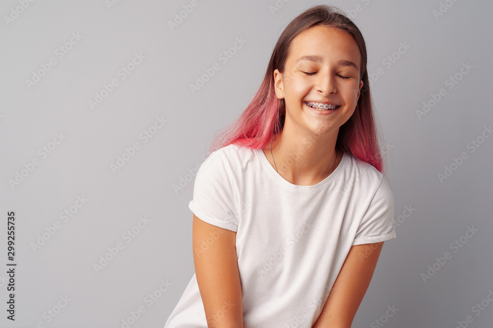 Young girl teenager with pink hair happy and smiling over gray background Young girl teenager with pink hair happy and smiling over gray background