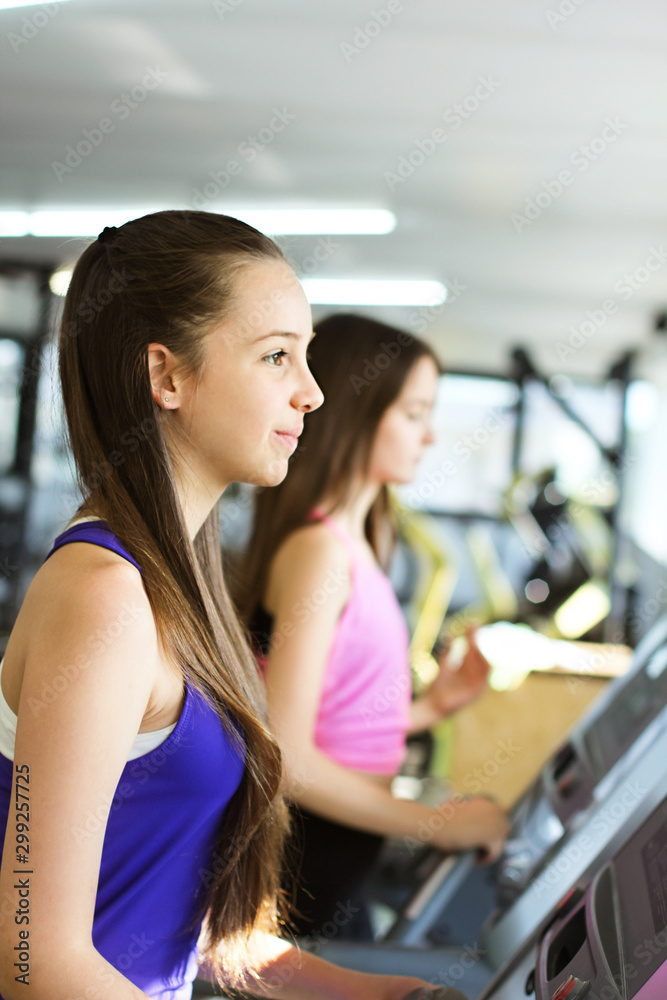 Teen girls training. Two beautiful teenage in the gym Teen girls training. Two beautiful teenage in the gym