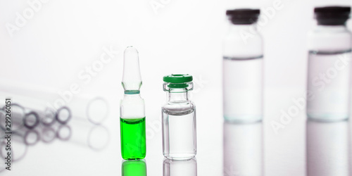 Group of vials with medication on blue methacrylate table.
