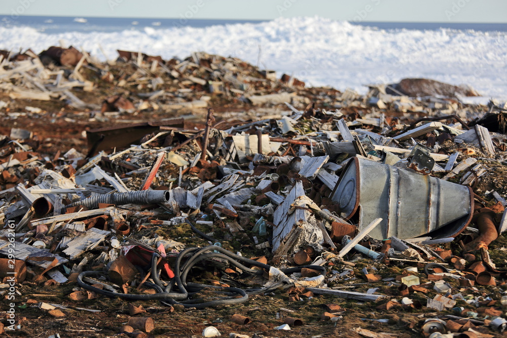 Fuel drums and piles of scrap metal waste in the Arctic