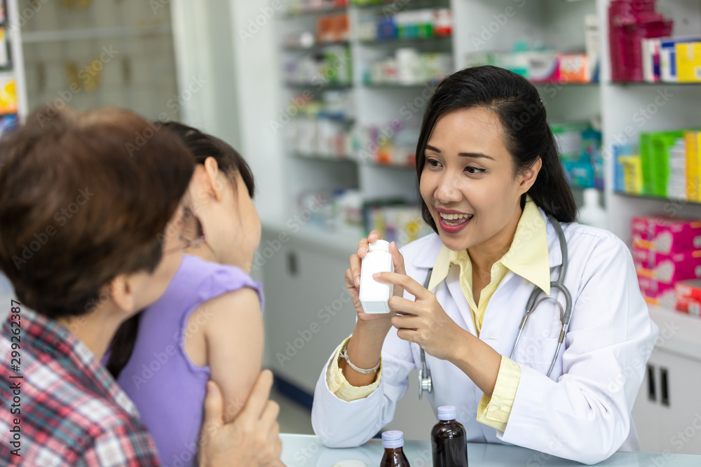 asian female pharmacist explain about how to use drug, she holding prescription with her hand and talk with smiling asian female pharmacist explain about how to use drug, she holding prescription with her hand and talk with smiling