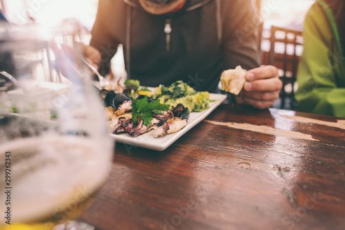 The man eats seafood in the restaurant.