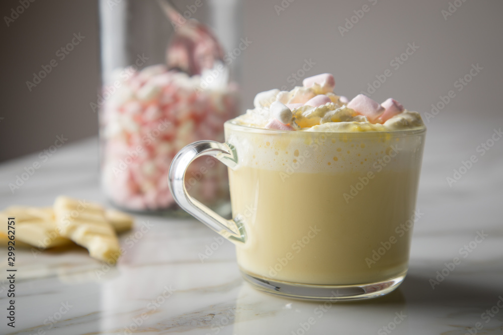 Heiße, weiße Trinkschokolade mit Sahne, Schokoladen Tafel und Marshmellows auf Marmor hell Hintergrund 