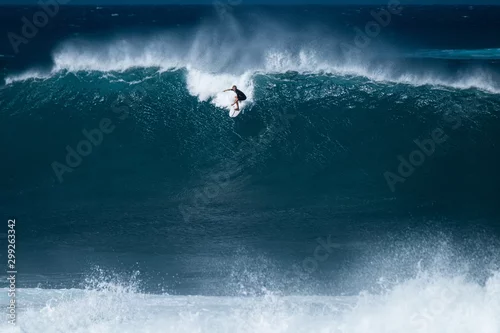 Obraz Surfer rides giant wave at the famous Banzai Pipeline surf spot located on the North Shore of Oahu in Hawaii