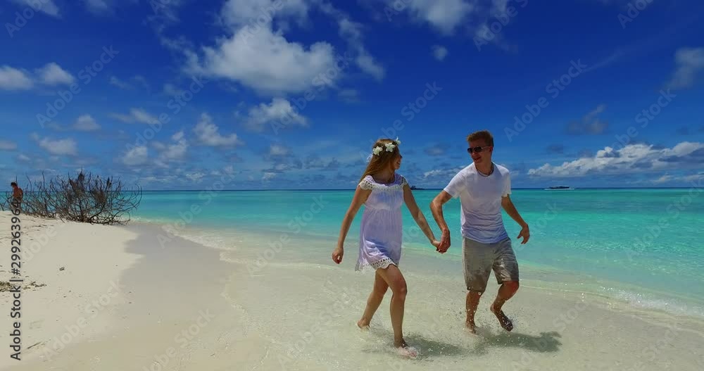 a couple running on a tropical beach in the Maldives a couple running on a tropical beach in the Maldives
