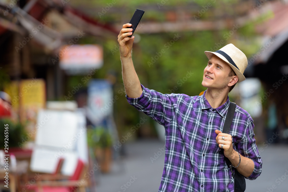 Portrait of young handsome tourist man vlogging with phone in the streets Portrait of young handsome tourist man vlogging with phone in the streets