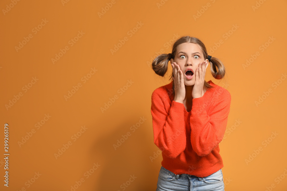 Obraz premium Surprised young woman on color background