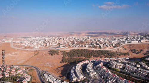 Wide Aerial footage of Israel and Palestine town divided by fence with Judean desert mountains 