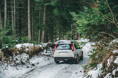 suv car with chain on wheels in snowed forest