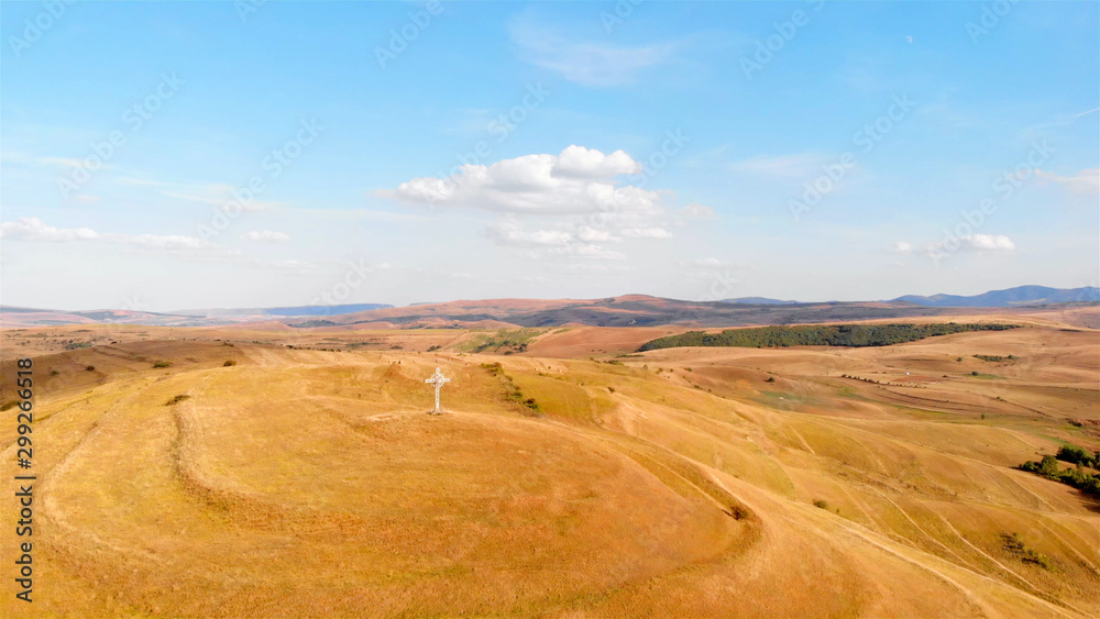 Aerial Imag over Large Cross  with Romania flag on High Hill and landscape at Summer