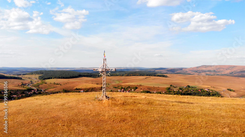 Aerial Imag over Large Cross with Romania flag on High Hill and landscape at Summer