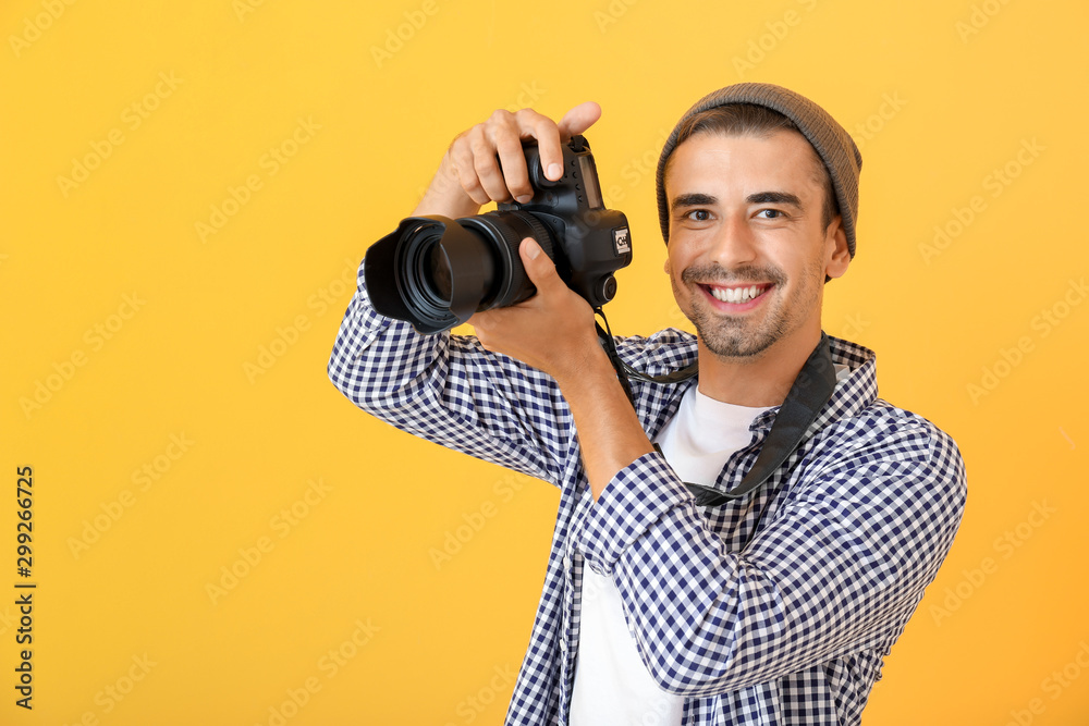 Young male photographer on color background - obrazy, fototapety, plakaty 