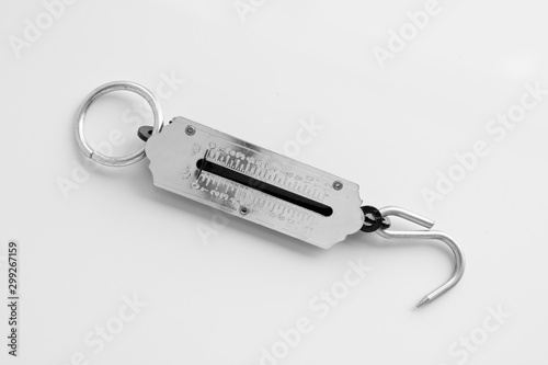 Silver steelyard with a hook on a light background. Kitchen utensils. Weighing tool.