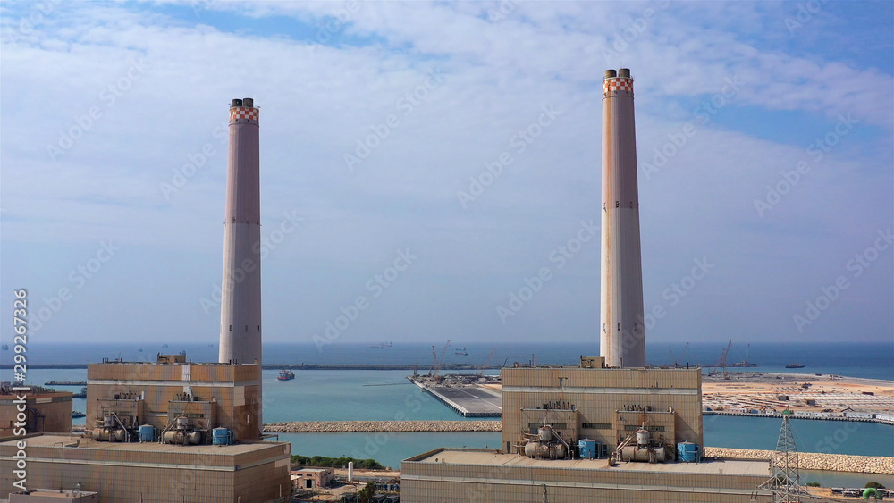 Power Plant with chimneys in Mediterranean sea, Aerial Image Drone view over Power Plant with chimneys and Mediterranean sea in the the background, Israel Power Plant with chimneys in Mediterranean sea, Aerial Image Drone view over Power Plant with chimneys and Mediterranean sea in the the background, Israel