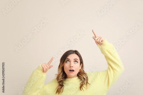Surprised young woman point...