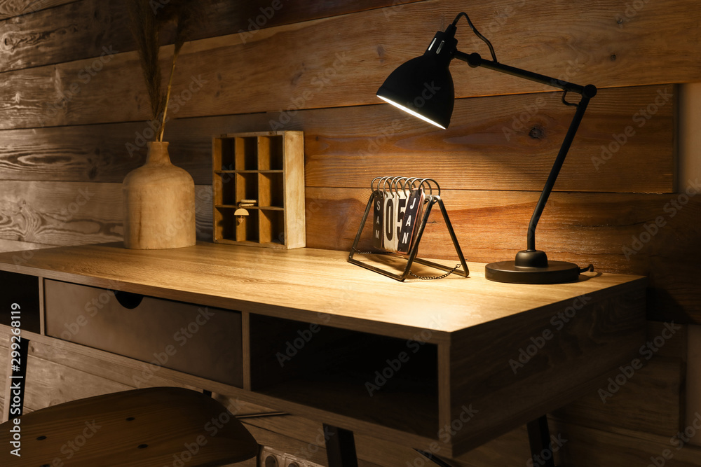Obraz premium Workplace with glowing lamp in darkness
