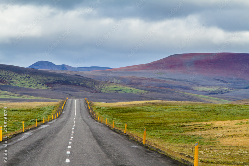 Einsame Straße zwischen farbenprächtigen Hügeln in Island