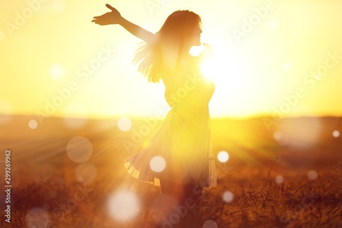 Young woman on field under sunset light