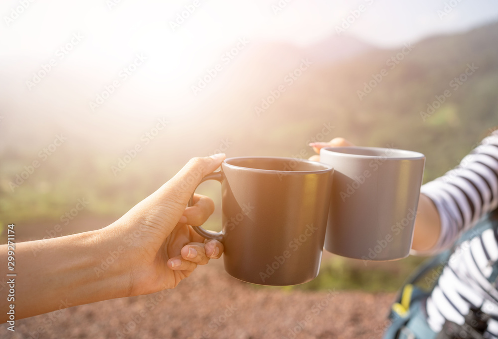 Closeup hands holding coffee cup drinking coffee or tea and nature  background.Hands clink hot coffee mug outdoor in the morning , friends  enjoy drinking together cheers for two cup in morning Photos