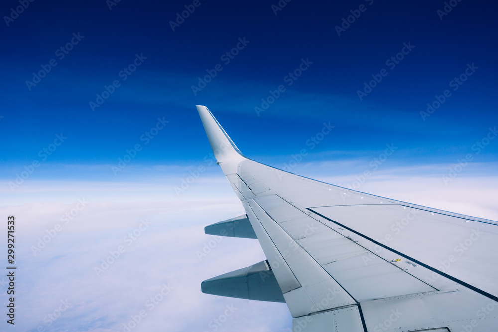 Wing of an airplane flying above the clouds