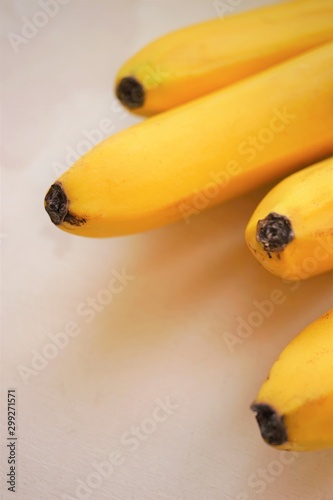 A bunch of ripe yellow bananas on the white table, close-up