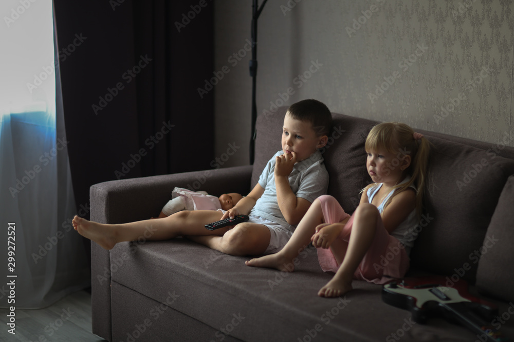 siblings brother and sister watch TV together