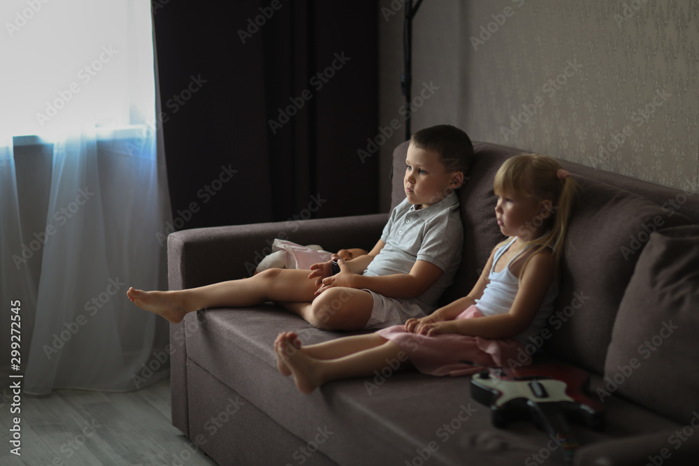 siblings brother and sister watch TV together