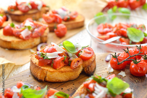 Knusprige Bruschette: Mit Olivenöl bestrichene gebackene Ciabattascheiben belegt mit Cocktailtomaten, Basilikum und Parmesan - Crispy baked Italian bread with cherry tomatoes, basil and parmesan