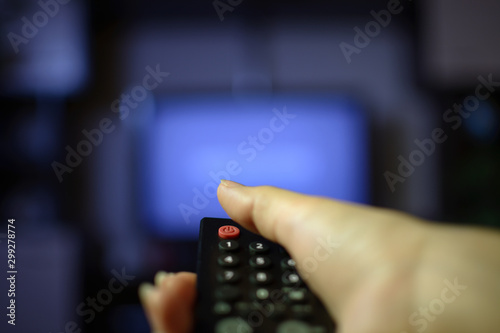Hand holds remote and turns on the TV