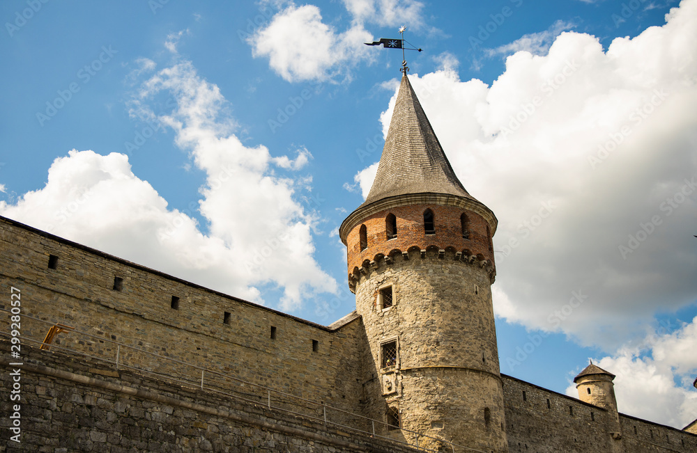 medieval castle wall tower fortification building on blue sky white clouds background 