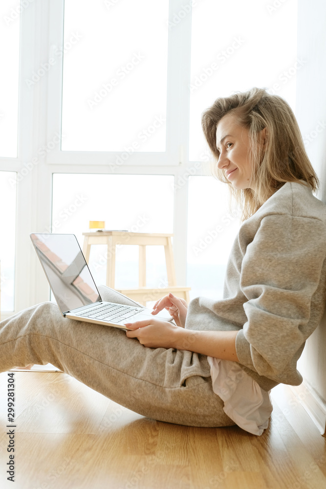 Smiling woman working on laptop in pyjamas Smiling woman working on laptop in pyjamas