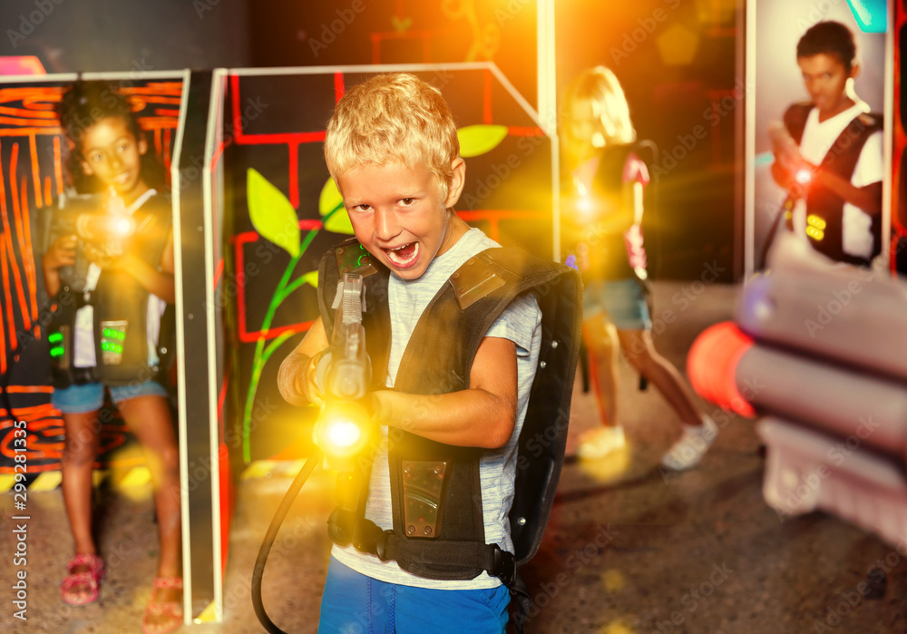 Fototapeta premium Preteen boy with laser pistol playing on labyrinth