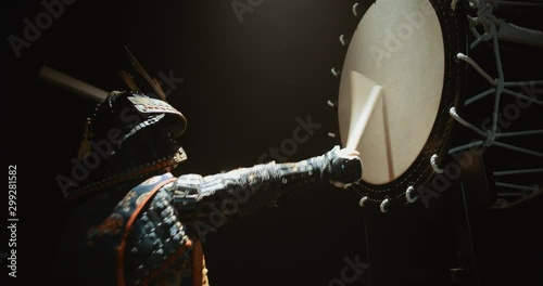 Japanese man in historical samurai costume playing on taiko drum with kata moves, isolated on black background - culture, history concept 4k footage photo