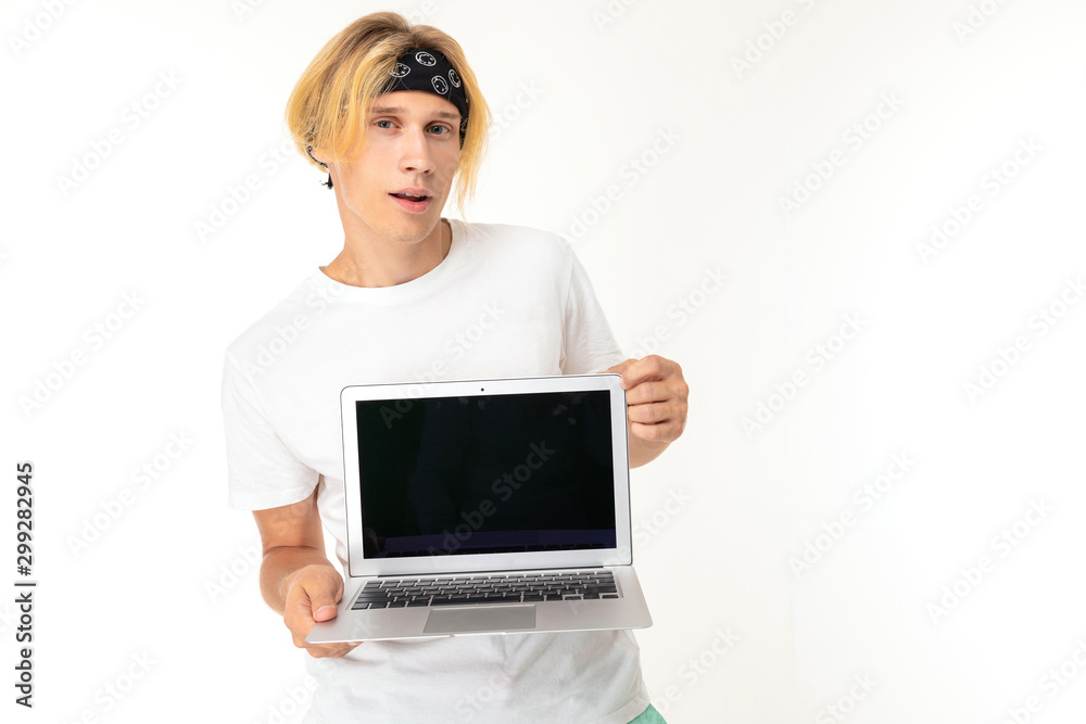cheerful student on a white background with a smile looks at the camera, holds a laptop in his hands with a blank screen on a white isolated background cheerful student on a white background with a smile looks at the camera, holds a laptop in his hands with a blank screen on a white isolated background