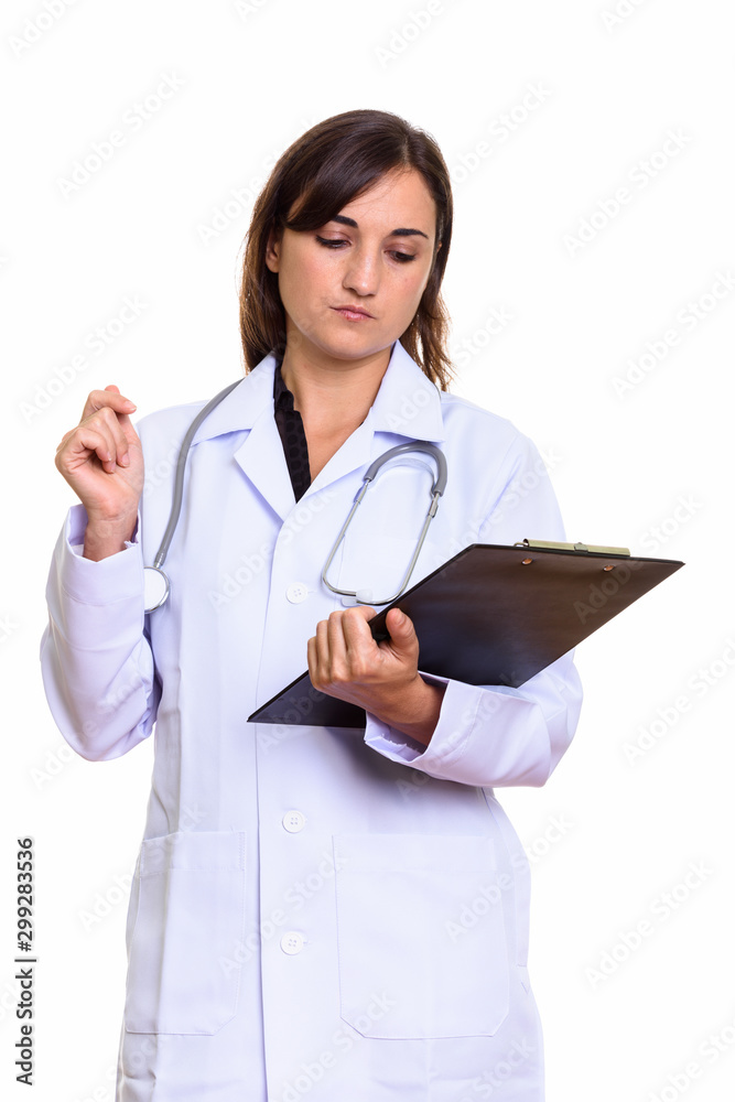 Studio shot of beautiful woman doctor reading on clipboard Studio shot of beautiful woman doctor reading on clipboard