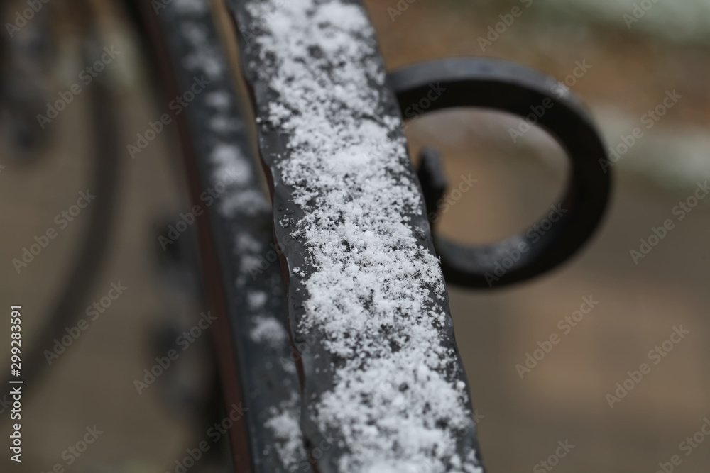 Iron railing covered with morning frost. Snow and ice texture.