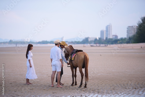Couples are happily riding horses on the sandy beach