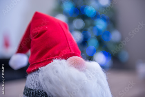 Creative background of a Christmas gnome sitting at the front of a Christmas tree