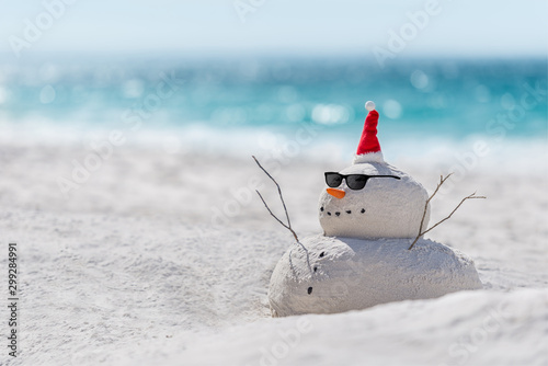 Fototapeta Naklejka Na Ścianę i Meble -  Christmas Sandy Snowman on a beautiful sand beach - Christmas symbol of countries where the weather is always warm