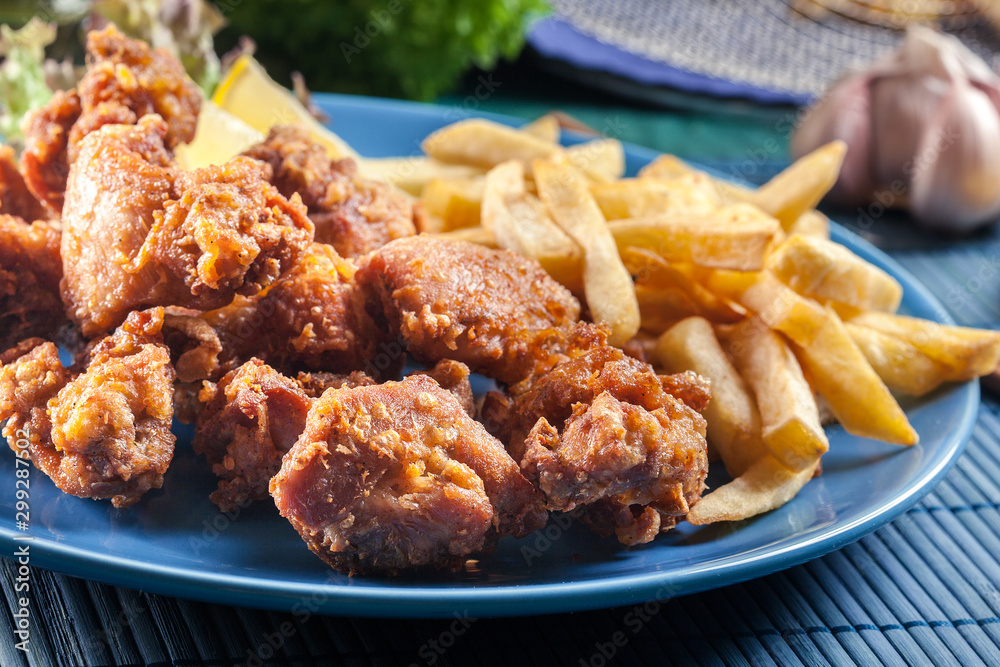 Obraz premium Crispy chicken karaage served with french fries