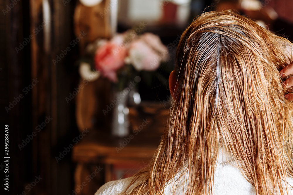 Hairstylist with brush applying mask to hair of her client in beauty hair salon. The process of keratin straightening, hair colouring. Hairstylist with brush applying mask to hair of her client in beauty hair salon. The process of keratin straightening, hair colouring.