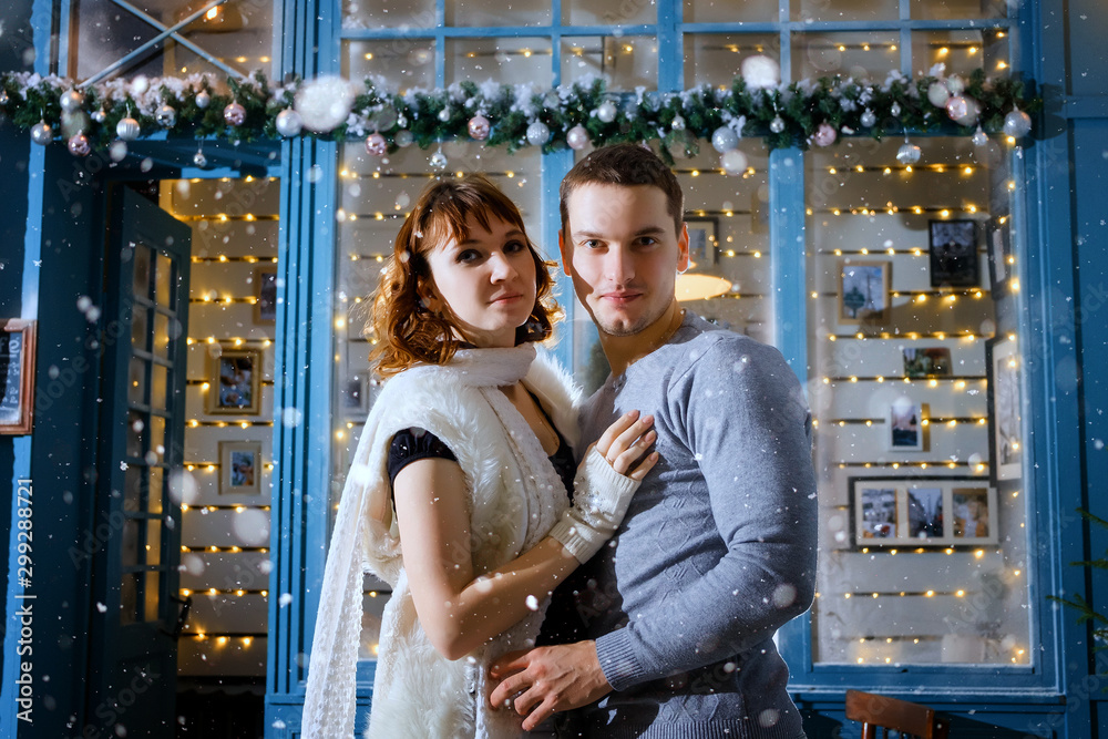 Portrait of a beautiful young couple over Christmas background
