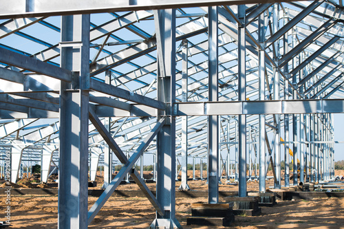 Steel frame workshop is under construction against a blue sky