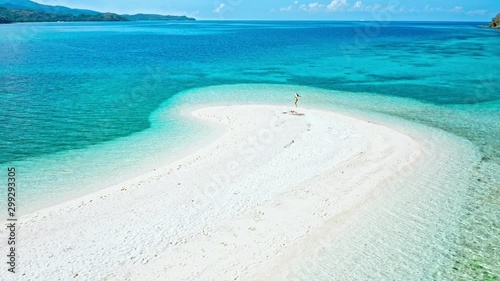 A concept of freedom. Happy woman walking on a spectacular white beach