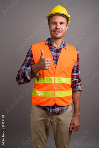 Portrait of handsome man construction worker against gray background © Ranta Images