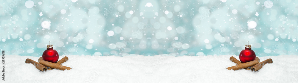 Red baubles and cinnamon sticks on snow snowflakes - Christmas winter background banner long