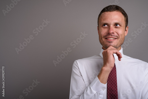 Portrait of handsome businessman against gray background