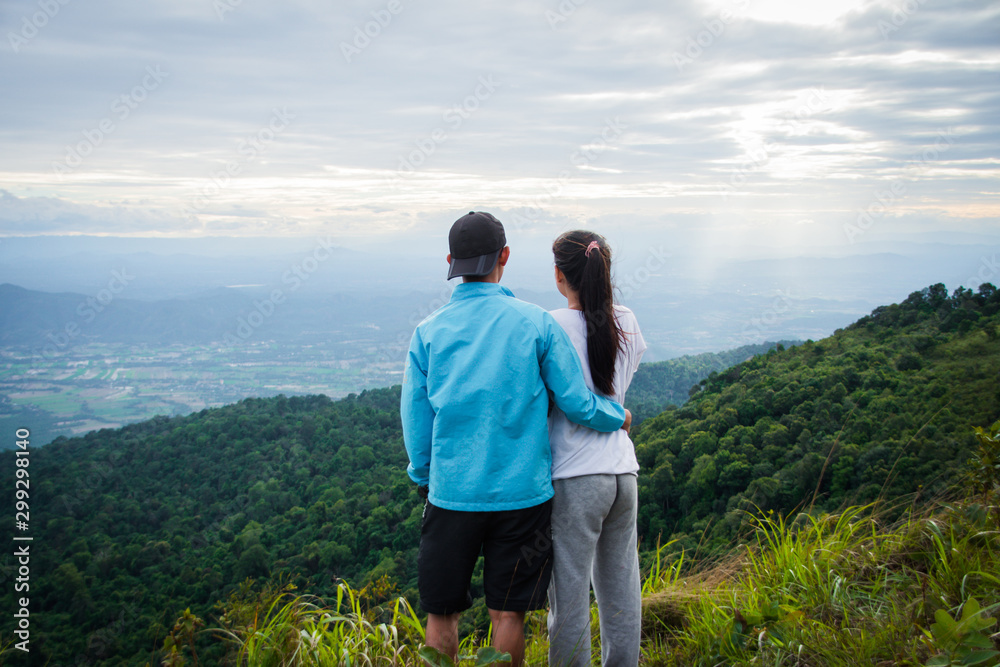 rear of couple love feel happy woman stand on top mountain looking view with mist and cloud