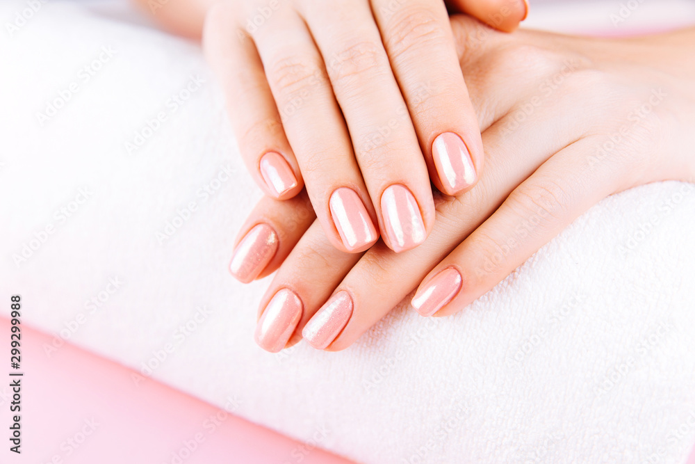 Beautiful Woman Hands on towel. Spa and Manicure concept. Female hands with pink manicure. Soft skin, skincare concept. Beauty nails. over beige background.